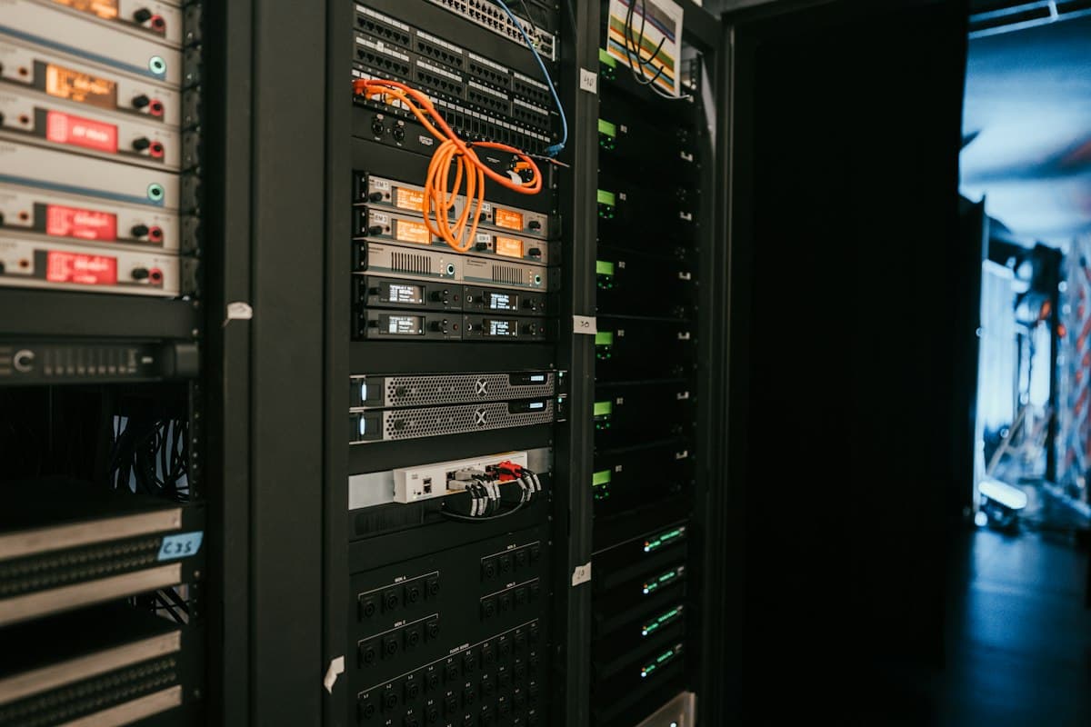 Rows of server racks with cabling in a data center, representing the infrastructure layer that enterprise coding-agent platforms are increasingly priced and budgeted like.
