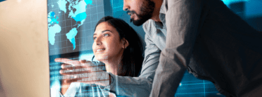 The image shows two professionals working on the computer, symbolizing the relevance of nearshore software outsourcing.