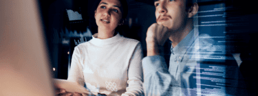 Professionals looking at computer graphics, symbolizing the software outsourcing in Latin America.