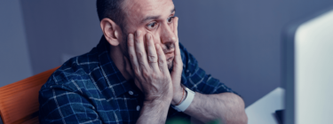 Man worriedly searching for his laptop, symbolizing the importance of UX for startups.